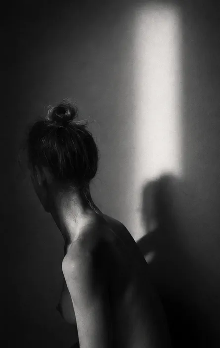 Figura di spalle nella luce di una finestra, bianco e nero